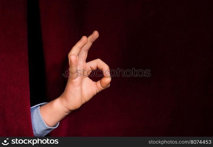 Hand symbol of success. Red curtain background