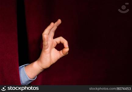 Hand symbol of success. Red curtain background