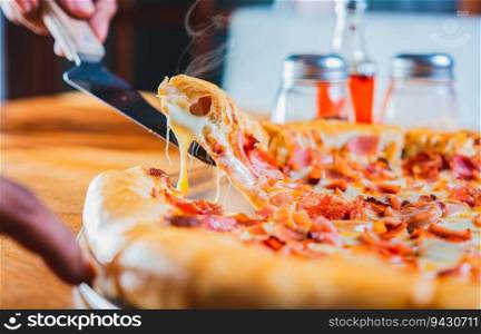 Hand taking a slice of ham pizza with the spatula. Person hand taking a slice of ham and cheese pizza with spatula
