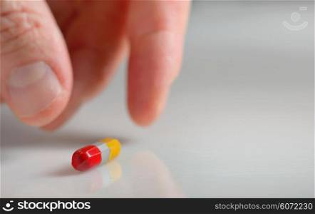 Hand taking the pill isolated