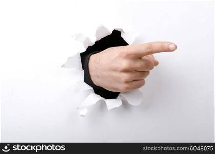 Hand through the hole in paper