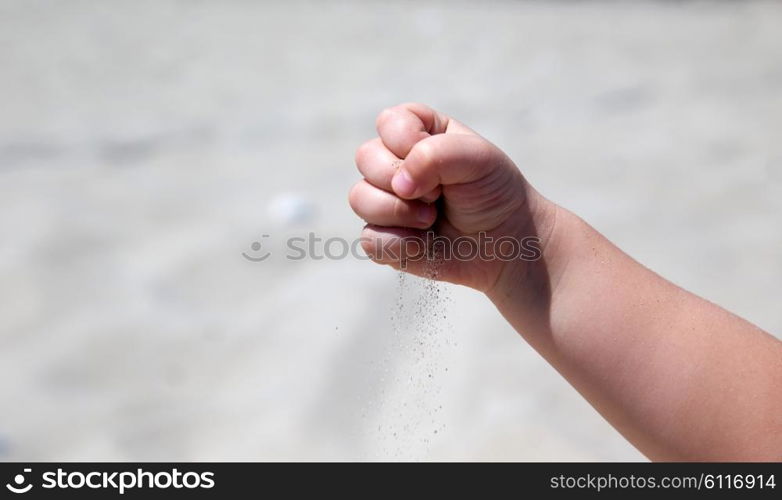 Hand throws sand on the seashore