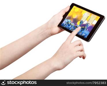 hand touches tablet pc with Christmas still life on screen isolated on white background