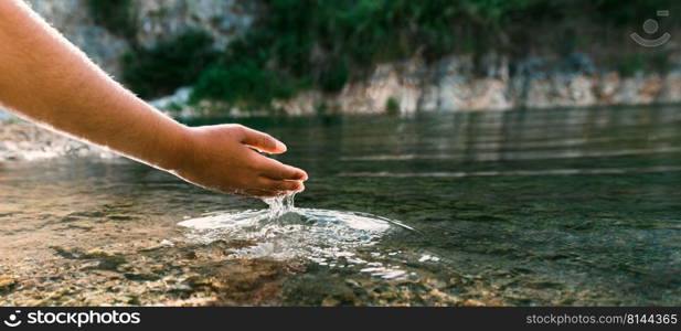 hand touches water in pond with sunshine