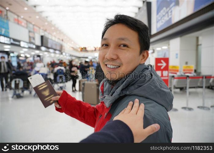 Hand touching on the asian shoulder for greeting friend at the airport when waiting flight on board, hand holding passport with big baggage, traveler and friendly concept
