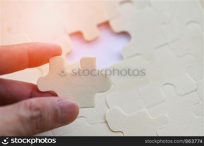 hand trying to connect jigsaw puzzle on background jigsaw piece connecting business solutions success and strategy concept