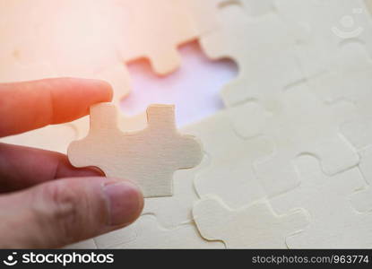hand trying to connect jigsaw puzzle on background jigsaw piece connecting business solutions success and strategy concept