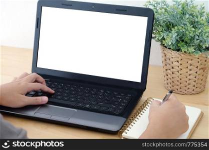 Hand typing laptop with blank screen and writing on notebook, background for mock up, technology, lifestyle