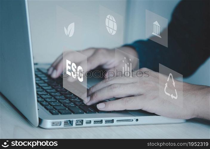 hand typing on computer laptop icon symbol of esg on vitrual screen concept. ESG (Environment, Social, Governance) investment concept that focuses on the environment, society and good governance.