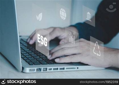 hand typing on computer laptop icon symbol of esg on vitrual screen concept. ESG (Environment, Social, Governance) investment concept that focuses on the environment, society and good governance.