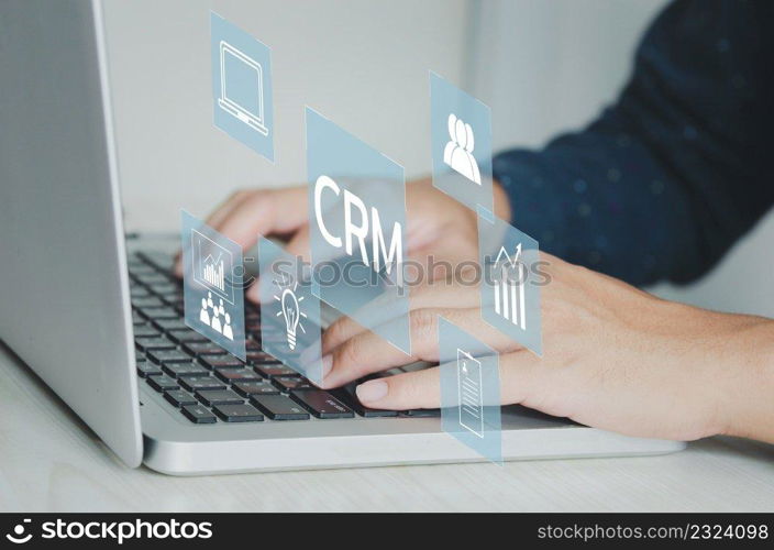 Hand typing on laptop concept. Icons CRM Customer Relationship Management business on virtual screen.