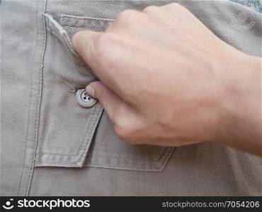 Hand unbuttoned his pants pocket gray Denim on background