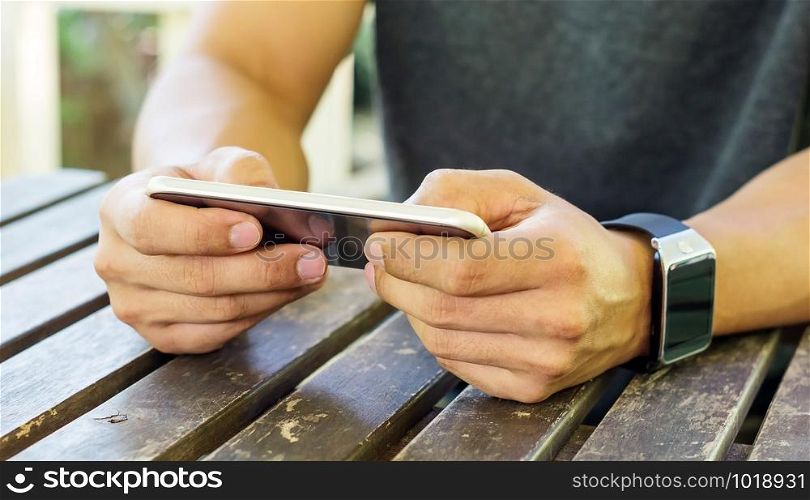 hand using a smartphone and a smartwatch.