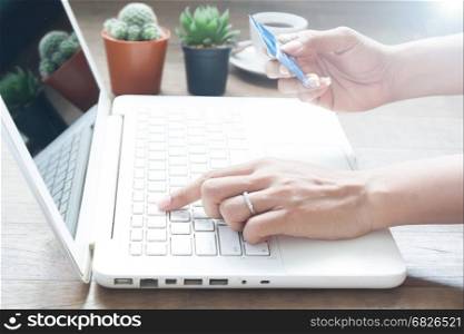 Hand using laptop computer and holding credit card, Online shopping concept