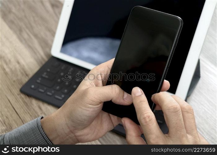 Hand using mobile payments online shopping,omni channel,icon customer network,in modern office wooden desk, blank interface screen