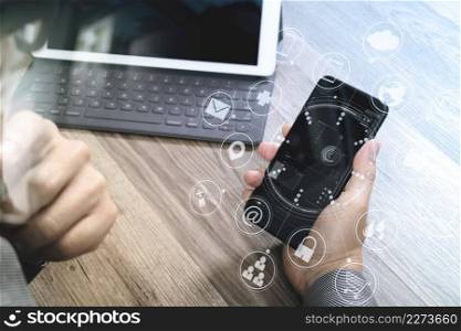 Hand using mobile payments online shopping,omni channel,icon customer network,in modern office wooden desk,graphic interface screen,eyeglass,filter