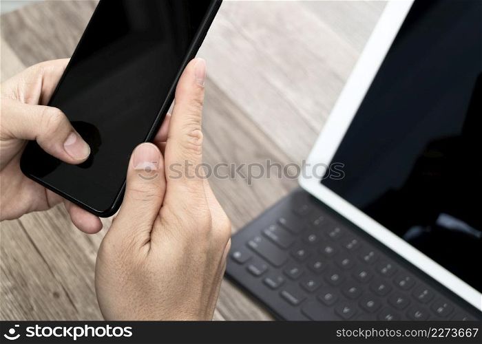 Hand using mobile payments online shopping,omni channel,icon customer network,in modern office wooden desk, blank interface screen,filter effect