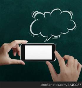 hand using mobile phone with speech bubble on chalkboard