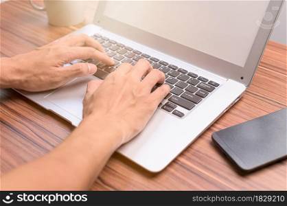 hand using notebook computer at the desk