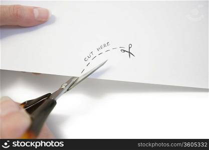 Hand using scissors to cut paper