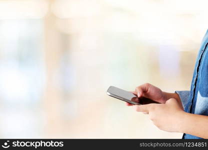 Hand using smart phone over blur bokeh light background, business and technology concept, digital marketing, seo, e-commerce, lifestyle, social media network, internet of things