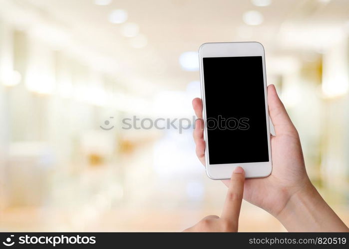 Hand using smart phone over blur bokeh light background, business and technology, internet of things concept