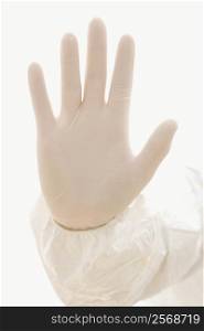 Hand wearing white rubber glove.