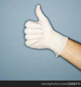 Hand wearing white rubber glove giving the thumbs up signal.