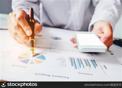 hand with a pen writing on the business paper. Report chart
