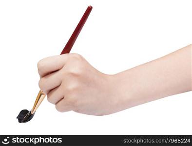 hand with artistic flat paintbrush paints in black isolated on white background
