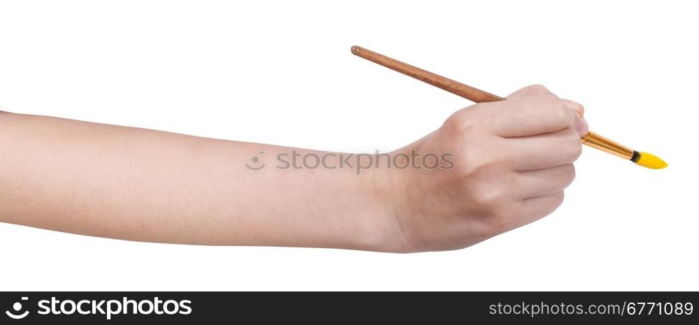 hand with artistic paintbrush paints in yellow isolated on white background