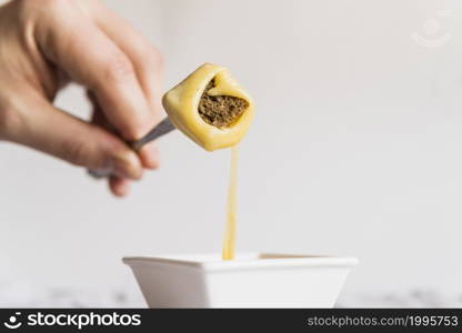 hand with bread cheese fondue pick