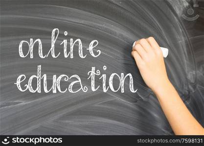 Hand with chalk writting on empty black board online education. Hand writting on black board