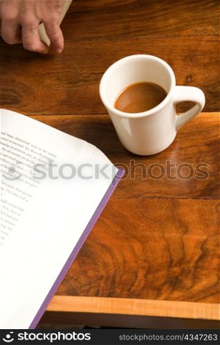 Hand with Coffee and Book