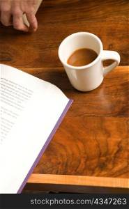 Hand with Coffee and Book