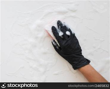 hand with glove cleaning surface with sponge foam