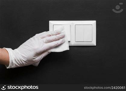 hand with glove disinfecting light switches