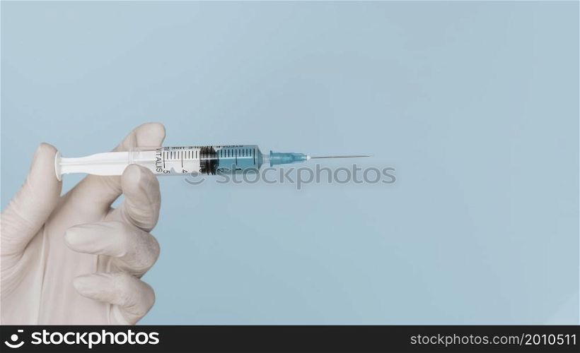 hand with glove holding syringe