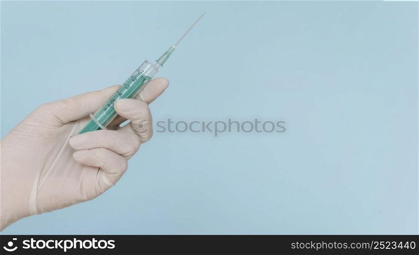 hand with glove holding syringe with copy space 2