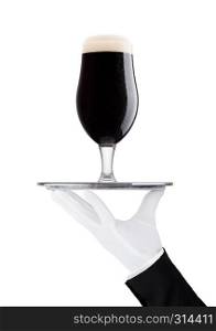 Hand with gloveholds tray with stout dark beer with dew on white background with reflection