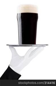 Hand with gloveholds tray with stout dark beer with dew on white background with reflection