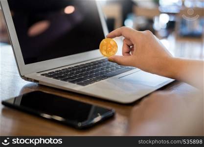 hand with golden metal Bitcoin crypto currency investment- symbolic block chain financial internet and technology