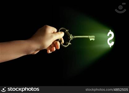 Hand with key. Close-up of human hand holding key. Money concept