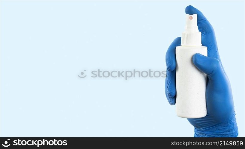 hand with latex glove holding spray bottle with copy space