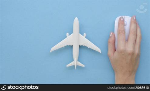 hand with mouse beside airplane toy