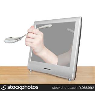 hand with soup spoon leans out TV screen isolated on white background