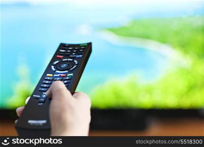 Hand with television remote control. Hand holding television remote control pressing buttons