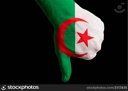 Hand with thumb down gesture in colored algeria national flag as symbol of negative political, cultural, social management of country