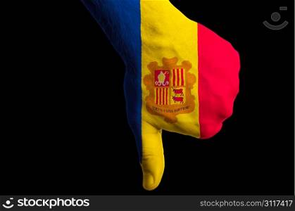 Hand with thumb down gesture in colored andorra national flag as symbol of negative political, cultural, social management of country