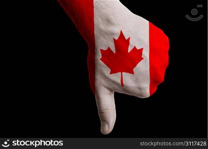 Hand with thumb down gesture in colored canada national flag as symbol of negative political, cultural, social management of country
